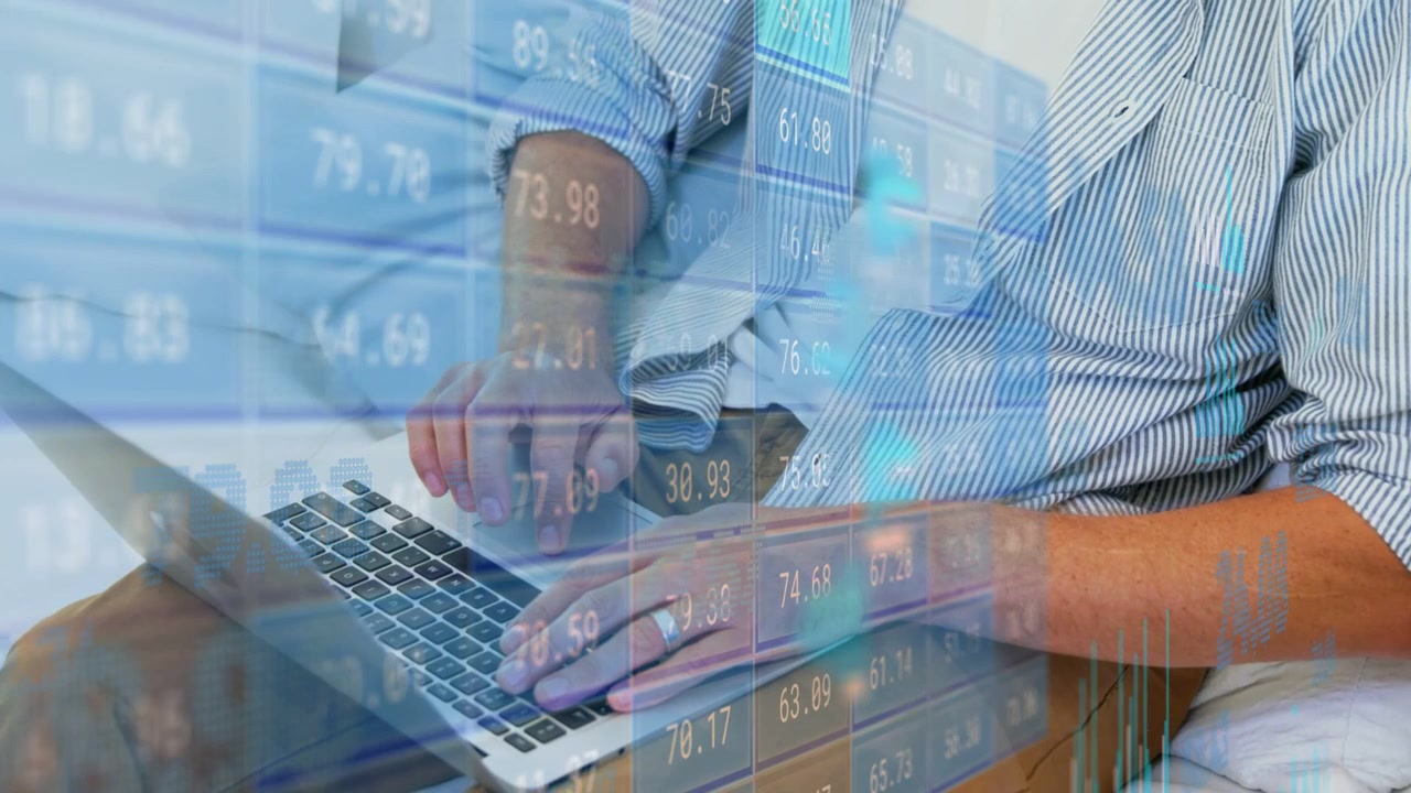 Mature man placing hands on keys, typing on laptop, analyzing financial overlays and charts at home