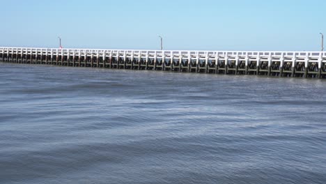 wide shot of tranquil water palisade on canal nieuwpoort during sunny day with blue sky in belgium