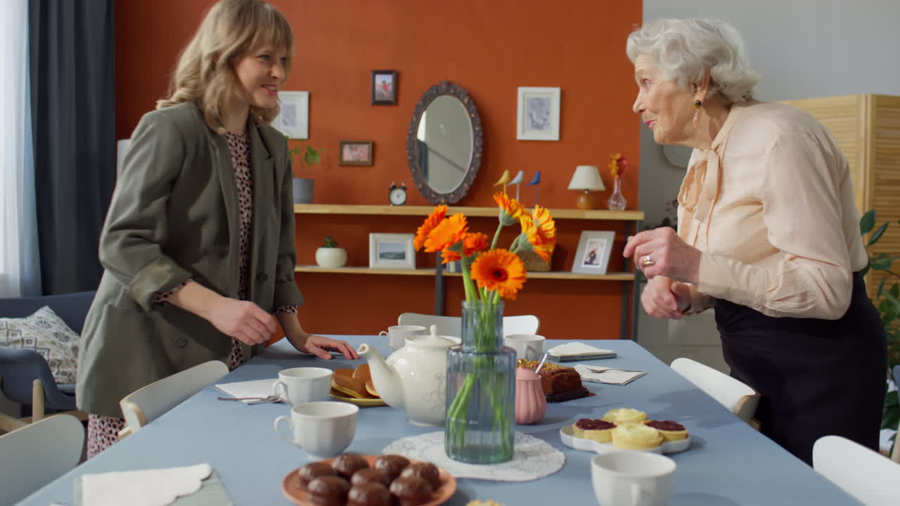 Woman Talking with Grandma while Preparing Holiday Dinner Table