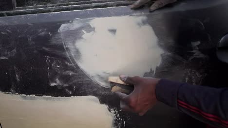 a mechanic repairs a car dent at a workshop in india