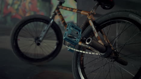 Casual-bmx-bike-standing-along-at-skate-park.-Bicycle-wheels-at-skatepark.