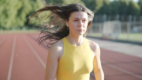 female athlete running on outdoor track in sportswear