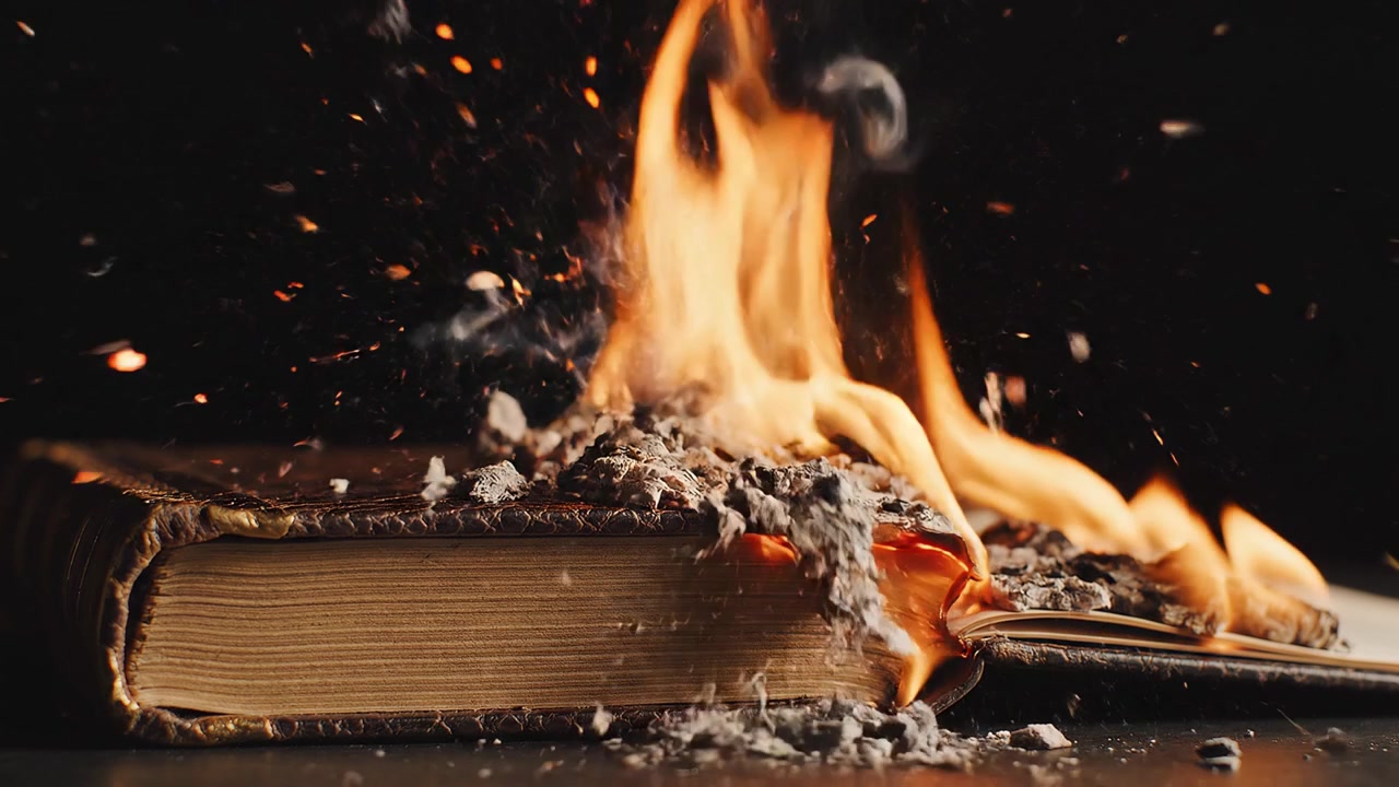Vecchio libro rilegato in pelle in fiamme su sfondo nero
