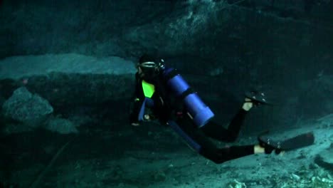 a scuba diver explores underwater caves in florida