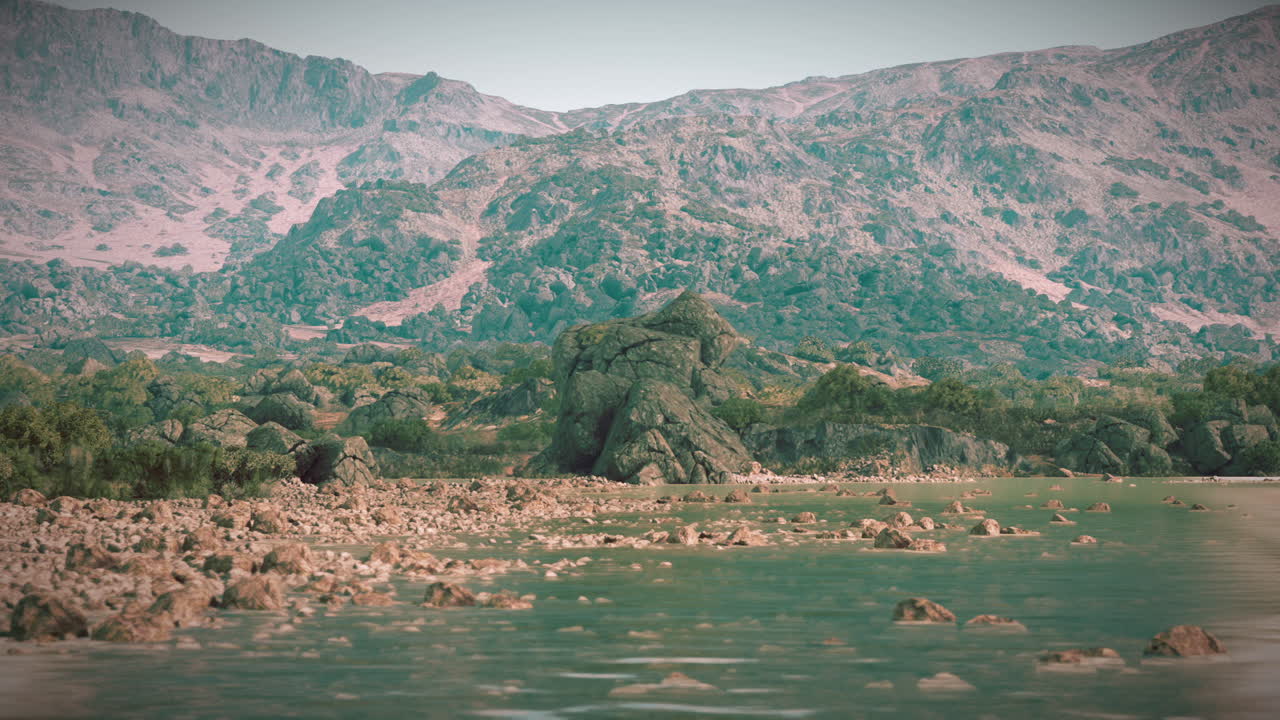 Gün batımında dağlarla çevrili, sakin bir gölde kayalık arazi
