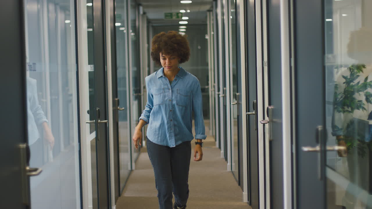 feliz joven mujer de negocios saliendo de la oficina celebrando en el corredor