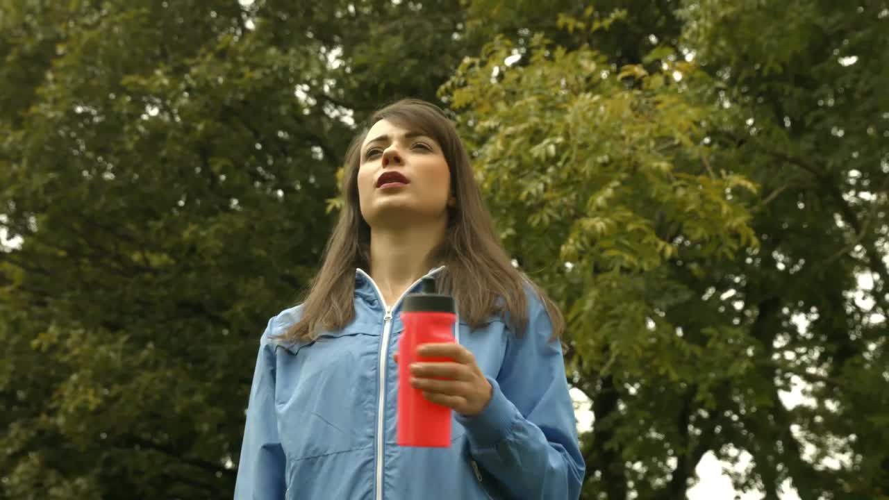 mujer cansada y en forma bebiendo