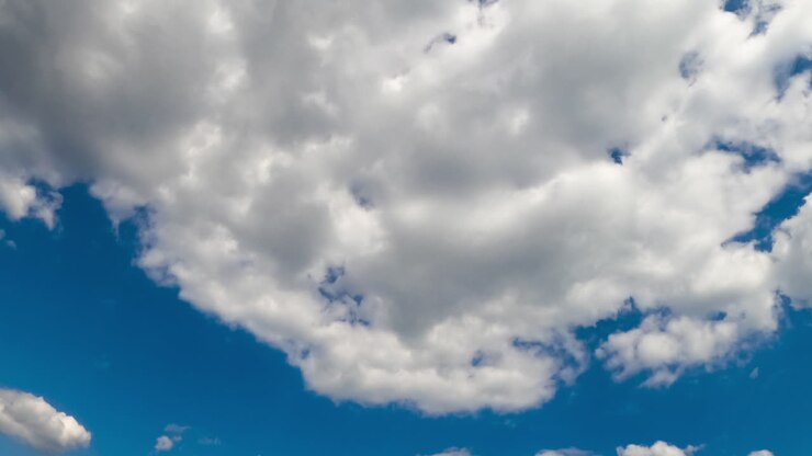 Cloudscape in the azure sky. Big cloud dissolving into little white clouds. Low angle view. Timelapse.