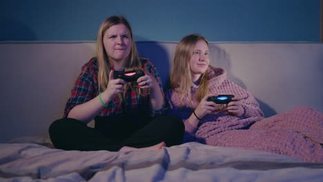 teenage girls gaming on a bed
