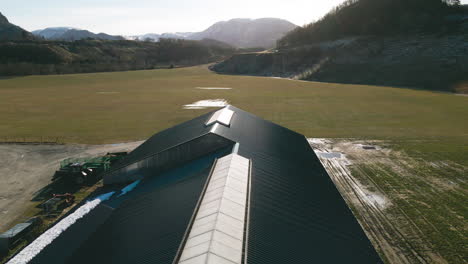 Volando-Sobre-El-Techo-Negro-De-Una-Casa-Granero-En-Una-Granja-Lechera-En-Noruega