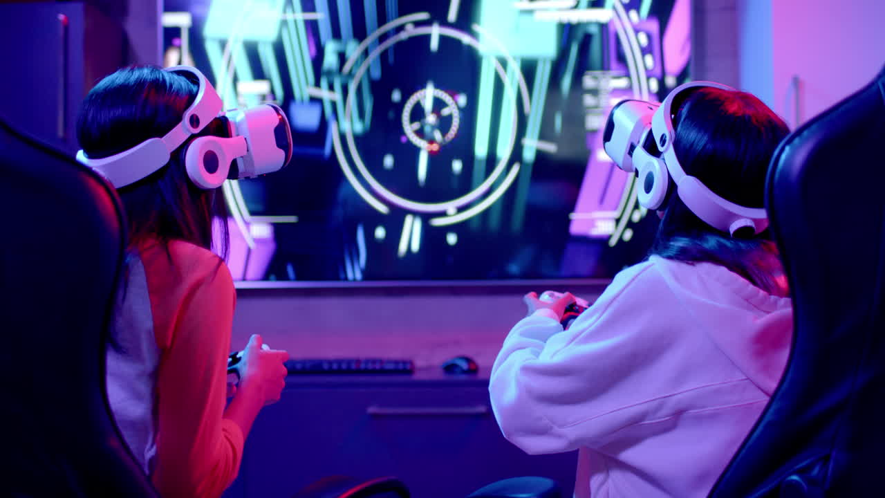 Using VR headsets and gaming controllers, teenage girls enjoying virtual reality gaming