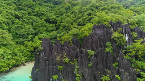 aerial shot of lime stone rock formations beside a blue lagoon in palawan philippines