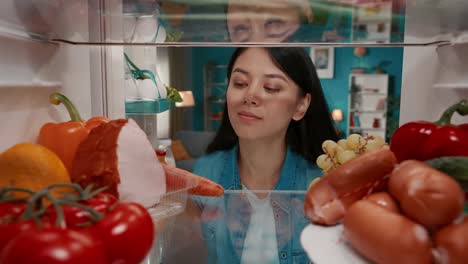 Woman Looking Inside a Refrigerator Filled with Food