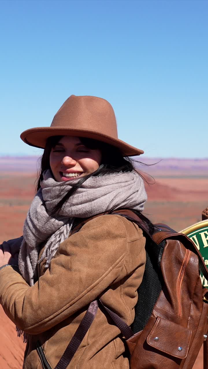 Donna viaggiatrice felice che sorride al punto panoramico della Monument Valley