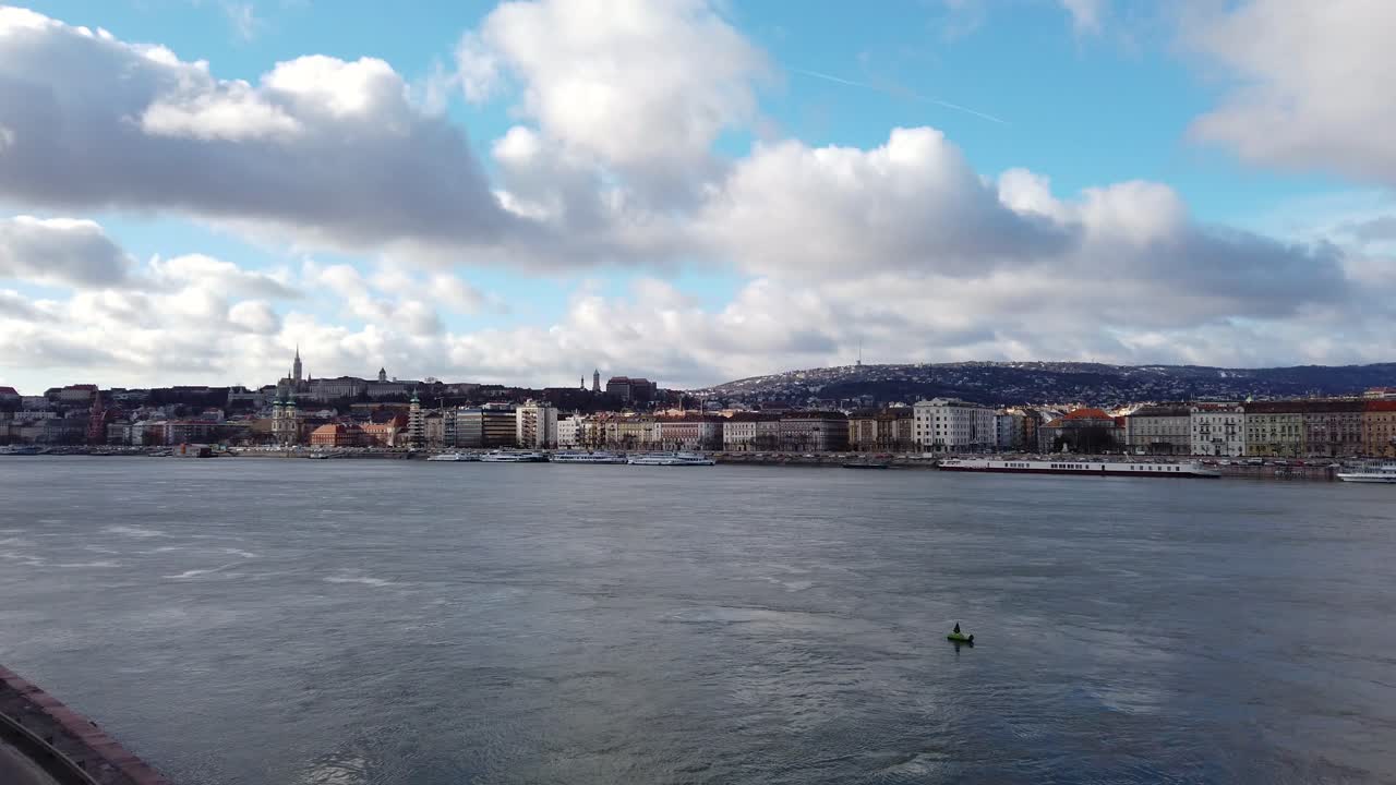 toma panorámica sobre el río danubio en budapest, hungría, con las colinas de buda y el parlamento al fondo, el edificio de oficinas del parlamento en primer plano, tomada desde el puente margarita.