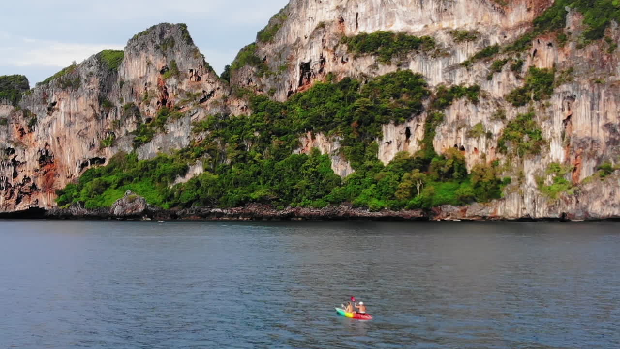 Couple paddling in a kayak on a beach at Ko Phi Phi, Thailand