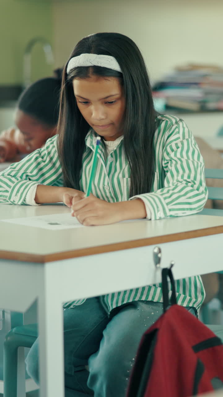 Focused Young Girl Writing on Paper at a School Desk
