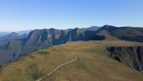 Aerial-flying-backwards-on-country-road-in-Serra-do-Corvo,-bus-traveling-alone