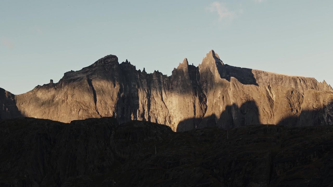 Pegunungan berbatu yang diterangi sinar matahari di Trollveggen, pemandangan udara mendaki