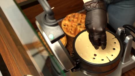 Hinzufügen-Von-Vorbereitenden-Topping-Schokoladenstückchen-In-Zeitlupe-Des-Waffeleisens-Oster-Gofrera