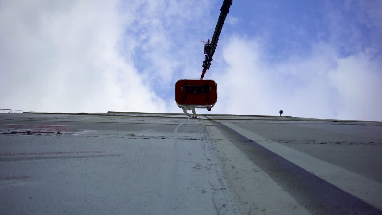 크레인을 사용하여 건물 외부 페인팅