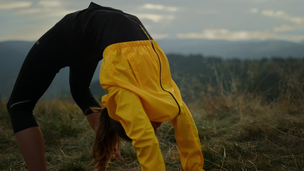 Frau macht die Yoga-Brücke. Sportliches Mädchen dehnt sich in den Bergen
