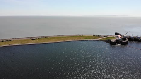 Aerial-forward-shot-of-Cardiff-Bay-walkway-and-Barrage-on-a-beautiful-sunny-day