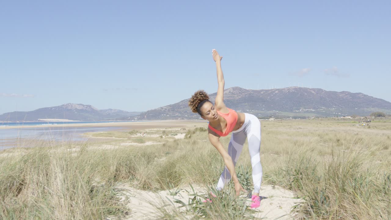 mujer estirandose junto al mar