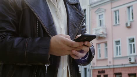 person using smartphone on city street