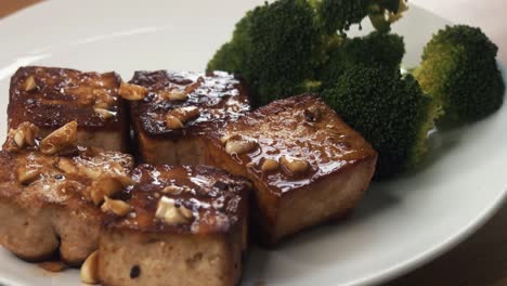primer plano de servir un plato de tofu y brócoli en la cocina