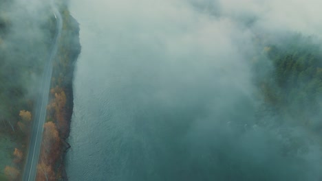 misty river and road through forest