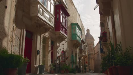 slow pan of a historic street with coloured balconies in birgu, one of the three cities of malta