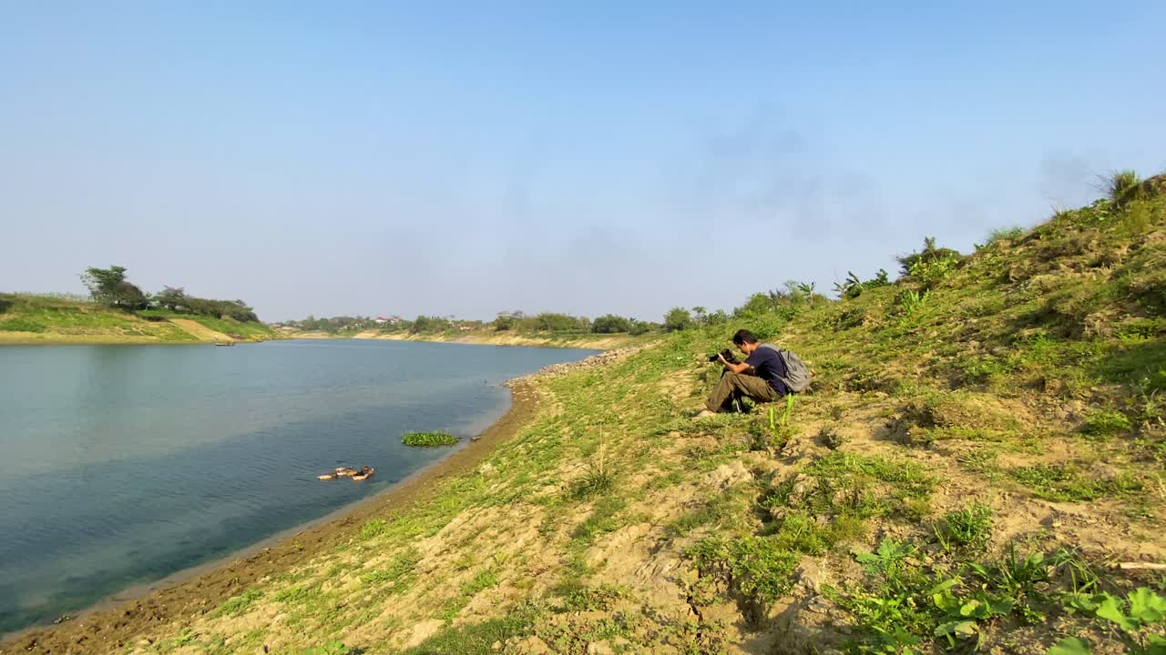 фотограф дикой природы фотографирует уток на склоне холма у реки сурма.