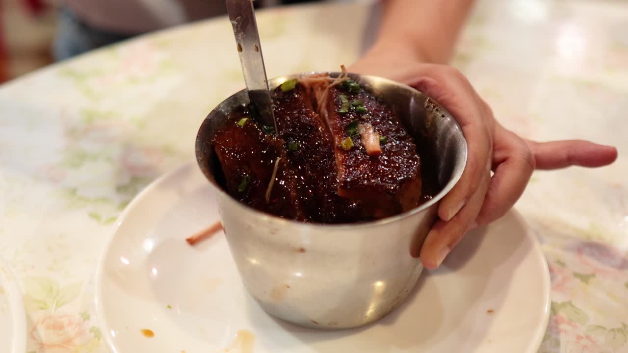 manos sirviendo carne de cerdo dongpo en el bazar de alimentos