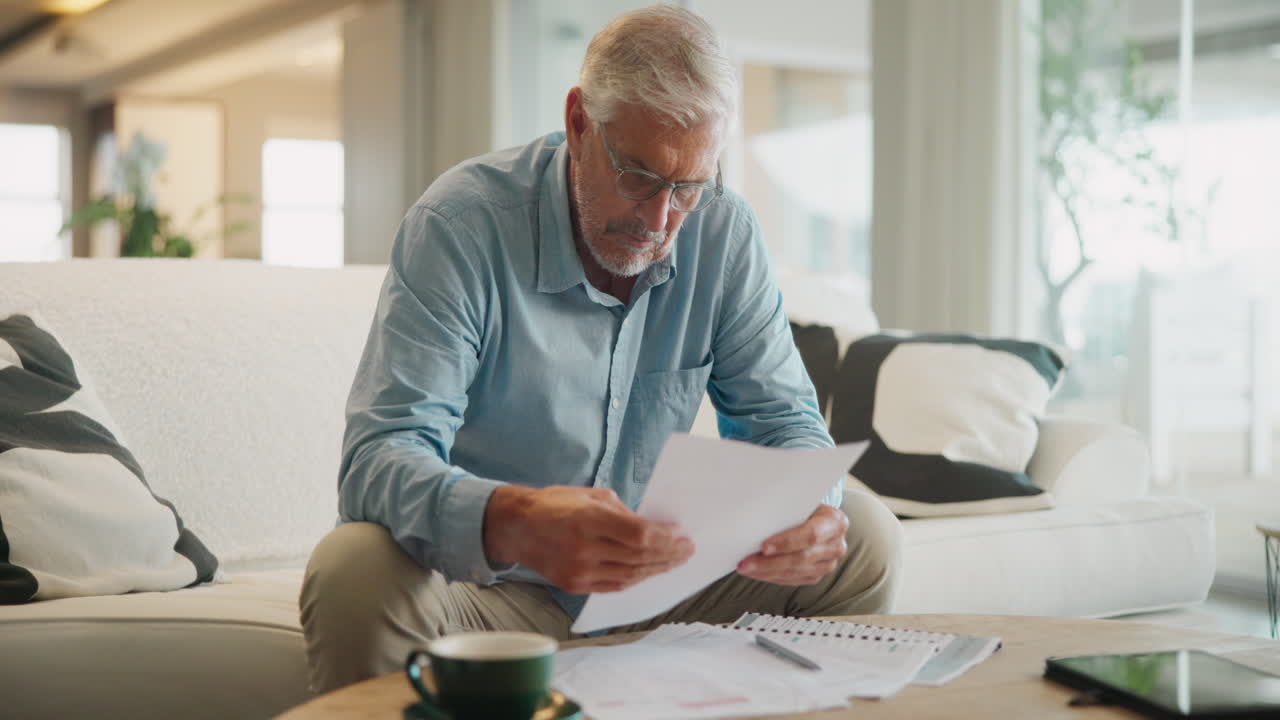 Senior man reviewing documents at home