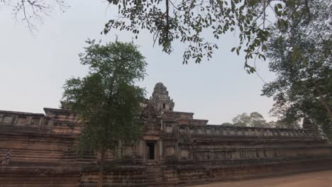 Walking-towards-the-entrance-of-a-wide-facade-of-a-temple-part-of-the-ruins-of-Angkor-Wat-in-Cambodia