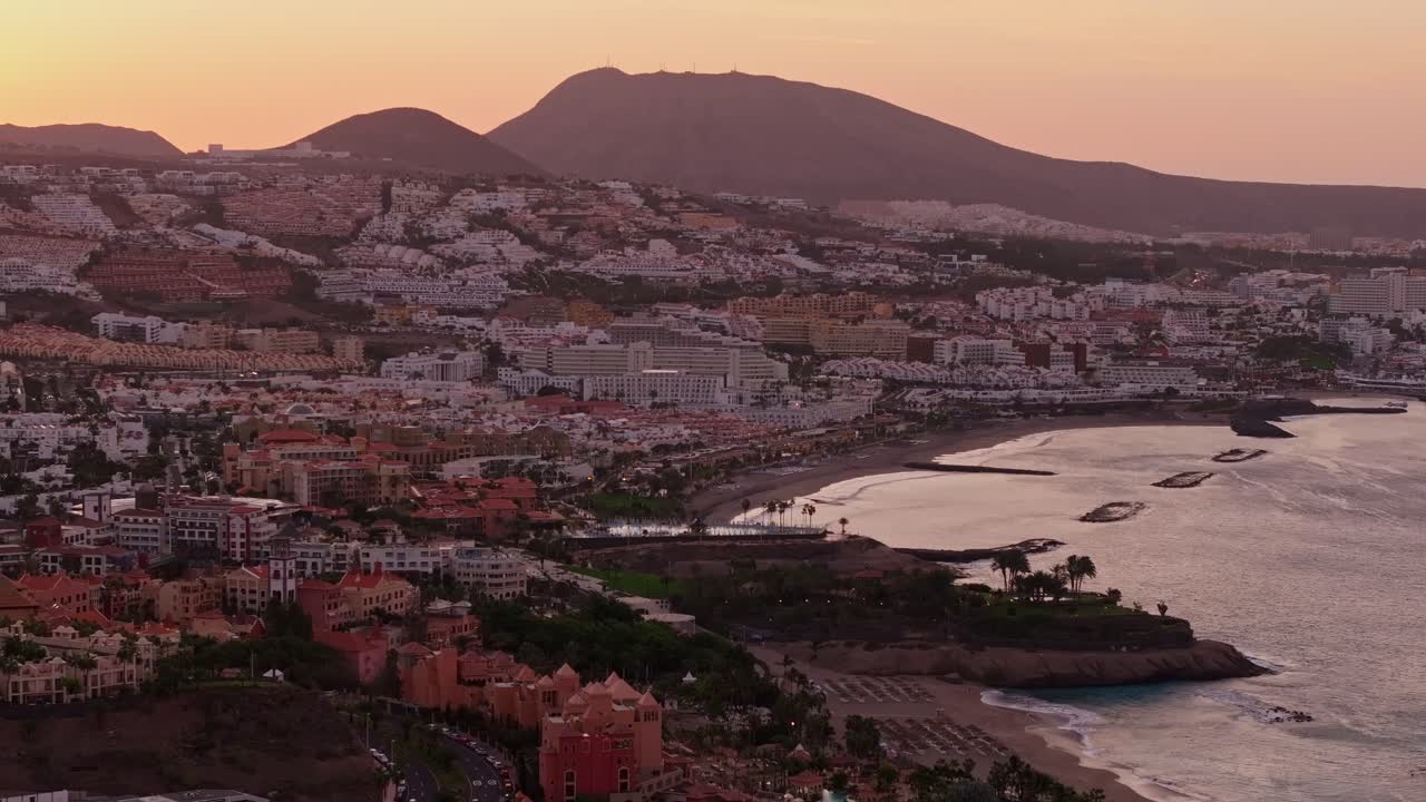 Peaceful sunrise above vibrant Tenerife resort town Costa Adeje, coastal hotels