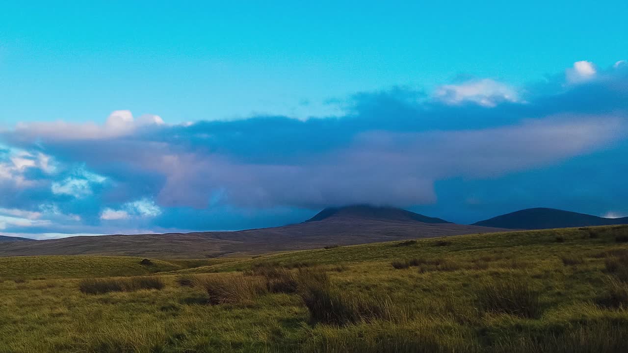 푸른 하늘에서 언덕과 날아다니는 클라우드스케이프가 있는 활기찬 풍경의 시간 경과