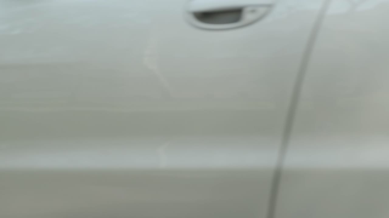 joven con discapacidad conductor entrando en coche rojo fom silla de ruedas