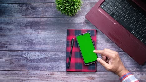 vista de ángulo alto de la mano del hombre usando teléfono inteligente con pantalla verde