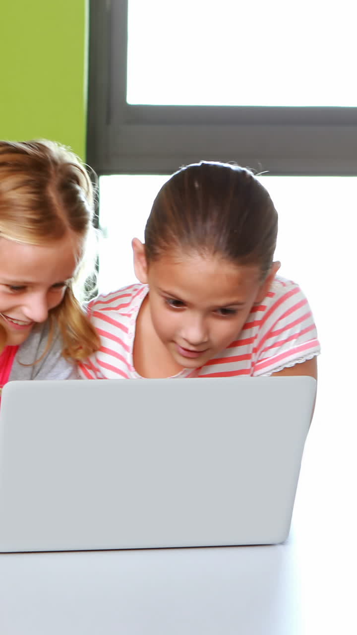 escolares que usan computadoras portátiles en el aula