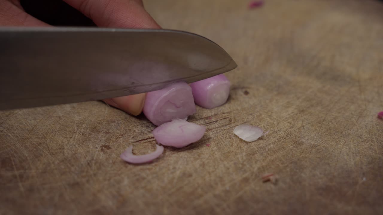 Close-up of Hands Chopping Red Onions on a Wooden Cutting Board