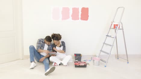 young couple use tablet to discuss colors