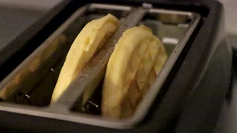 super close up view from top of two golden crispy waffles in toaster.