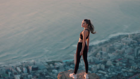 Mujer-Independiente-Con-Los-Brazos-Levantados-En-La-Cima-De-La-Montaña-Celebrando-El-Logro-Chica-Al-Borde-Del-Acantilado-Mirando-La-Hermosa-Vista-Al-Atardecer-Disfrutando-De-La-Aventura-Del-Viaje