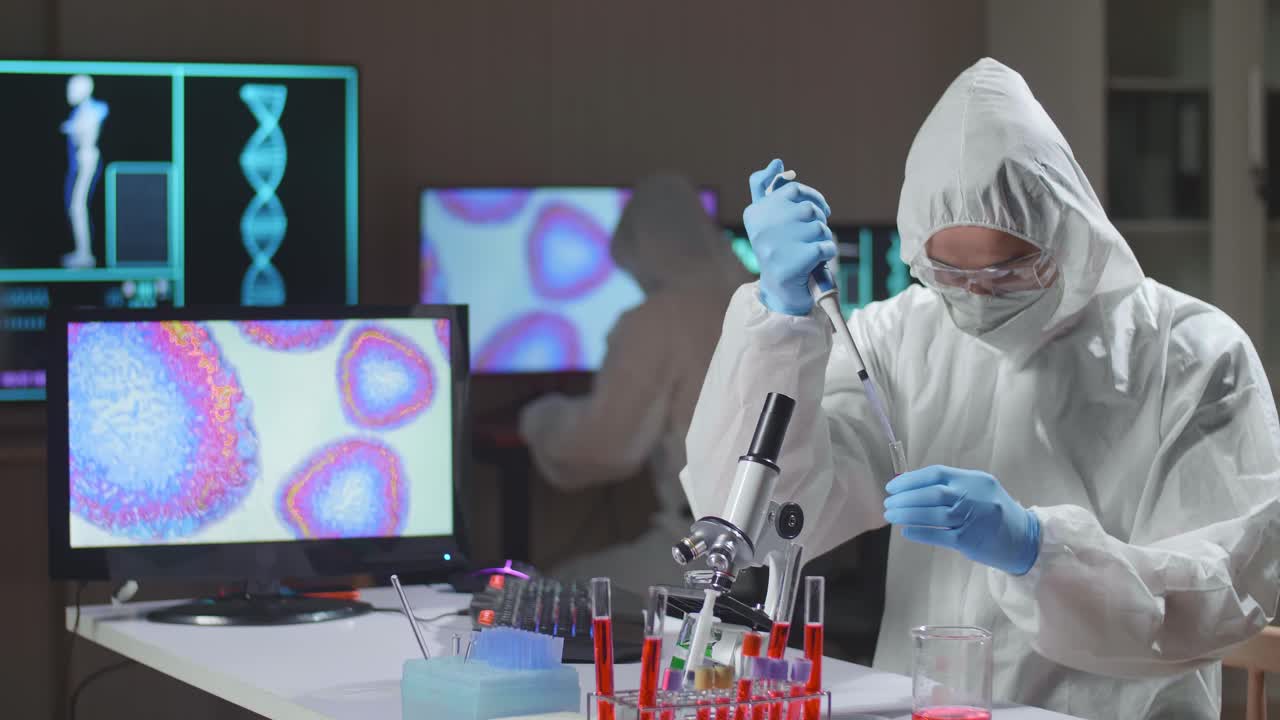 Doctor In Protective Suit Is Doing A Science Experiments And Developing Vaccine In A Modern Lab. Laboratory Assistant Workplace. The Concept Of Science And Medicine