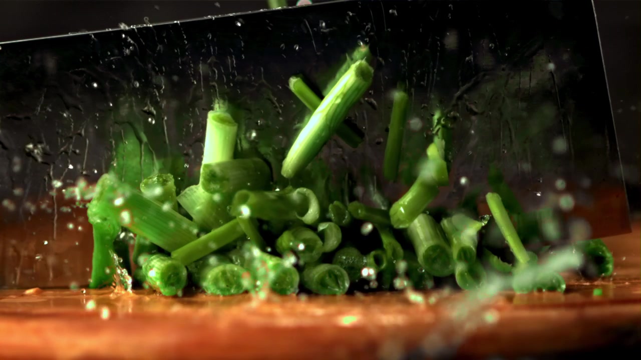 Slow Motion Chopping Fresh Green Onions on a Wooden Board