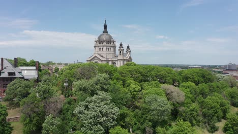 aerial rising shot over the treetops to reveal the massive cathedral of saint paul in minnesota