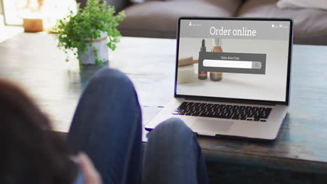 woman at table using laptop, online shopping for beauty products, slow motion