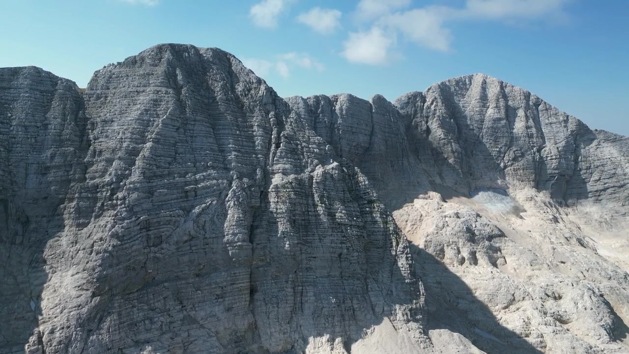 Images de drone aérien du Monte Canin dans le Frioul, Italie : pics calcaires accidentés, crêtes rocheuses et terrain alpin spectaculaire sous un ciel clair. Idéal pour les projets nature, voyage et plein air